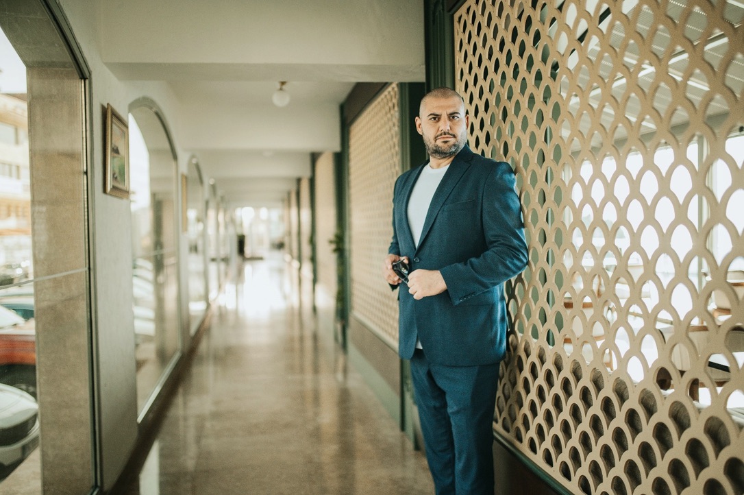 Baturbey Seyhan, desenli bir koridorda lacivert takımıyla